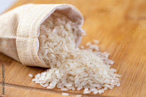 Rice grains on wooden background.
