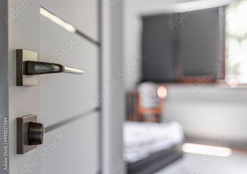 Close-up of metal doorknob on blurred background of home interior.