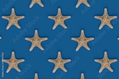 Exotic starfish pattern on blue background. Aged starfish wallpaper. Aquatic backdrops