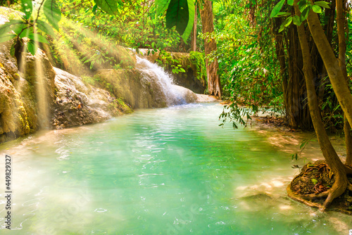 Tropical landscape with beautiful waterfall lake, wild rainforest with green foliage and flowing water. Erawan National park, Kanchanaburi, Thailand