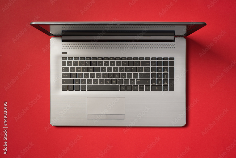 Fototapeta premium Top view photo of open grey laptop on isolated vivid red background