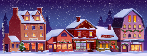 Christmas landscape street with decorated houses at night time, snowfall, snowy weather. Vector Xmas home buildings with chimneys, snow on ground, cafes and shops, urban city exterior