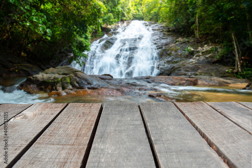 Wooden floor or plank on Green Forest and water fall on the blurred background  For product display.