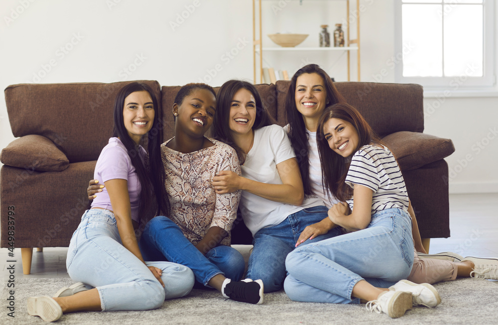 Best friends. Portrait of five different women in casual clothes hugging while sitting on the floor in the living room at home. Concept of friendship between different races and female friendship. Best friends. Portrait of five different women in casual clothes hugging while sitting on the floor in the living room at home. Concept of friendship between different races and female friendship.