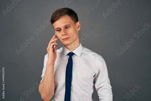 business man in a shirt with a tie with a phone in his hands communication work