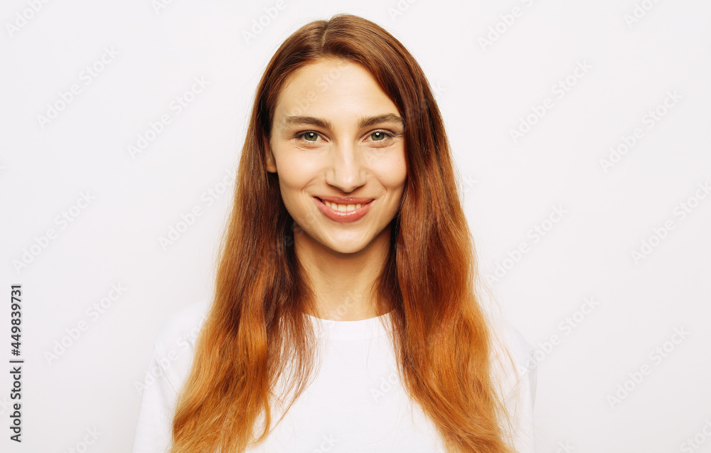 People, happiness and facial expressions concept. Pretty young woman with long red hair and cute smile People, happiness and facial expressions concept. Pretty young woman with long red hair and cute smile