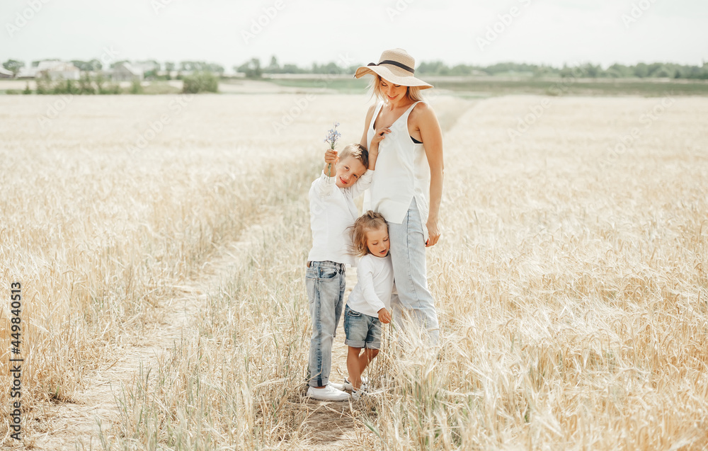 Family values. Happy mother and her children spending time together in sunny field.