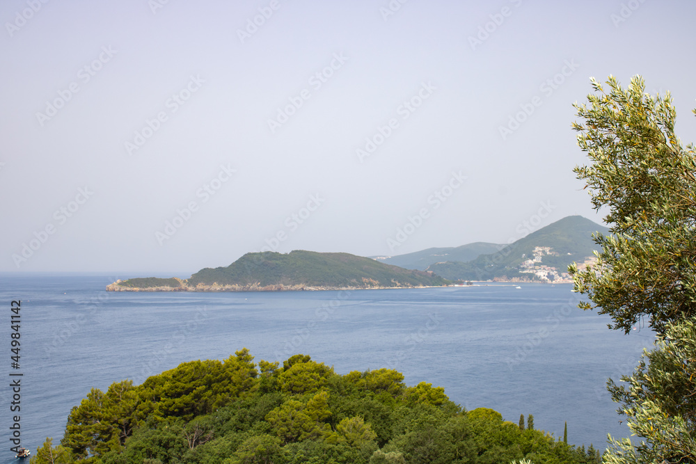 Landscape with blue sea and green mountains against the background of a clear sky. Panoramic beautiful view. Balkans on a wonderful summer day.