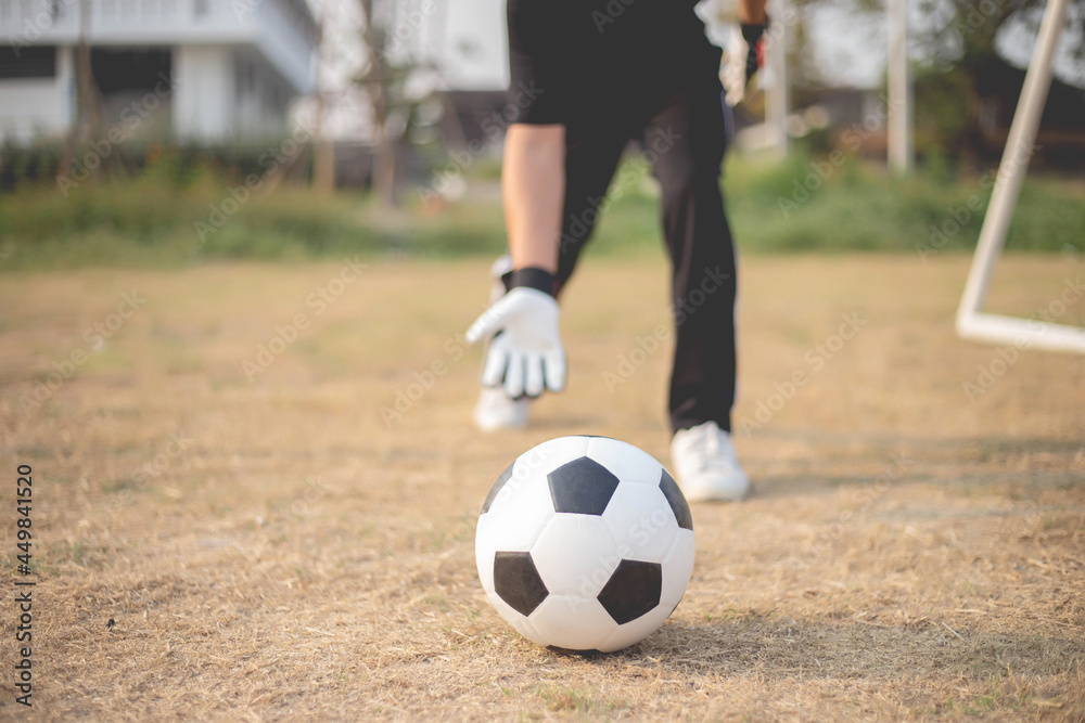 Fototapeta premium Sports and recreation concept a male goalkeeper standing in front of the goal throwing a ball as distributing in to a player after protecting the goal