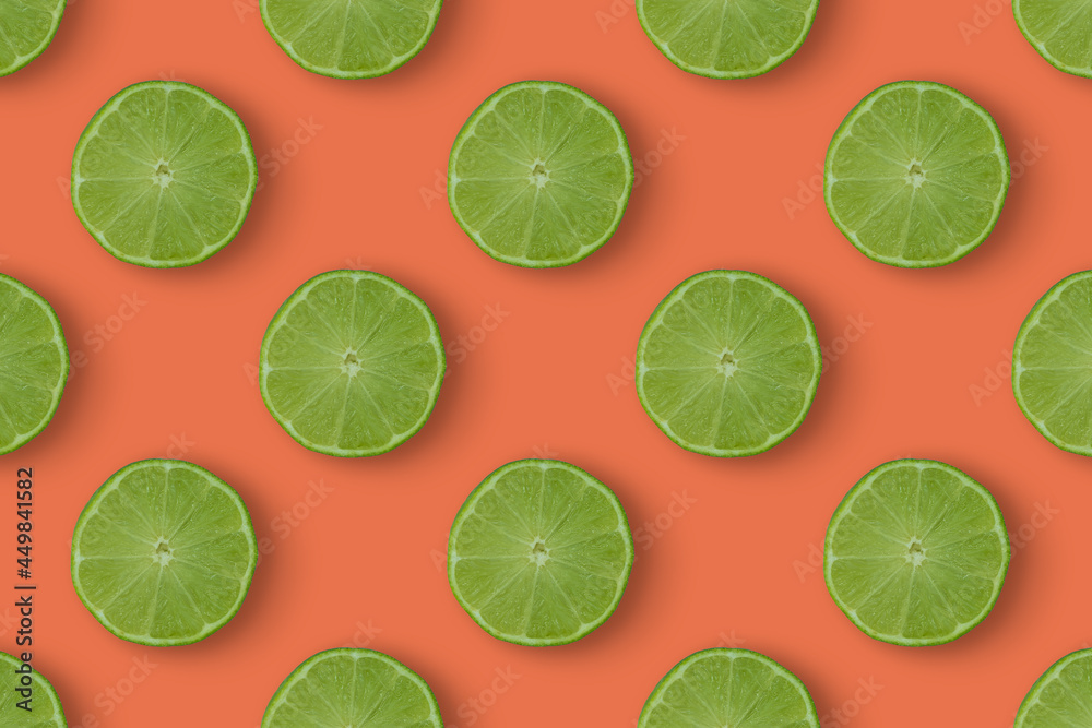 Juicy limes pattern on pastel orange background. Tropical wallpaper