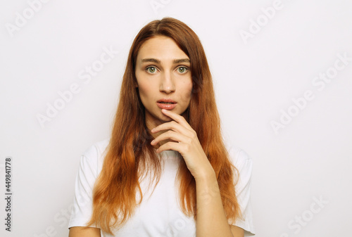 A young woman looks scared, worried, surprised or upset.