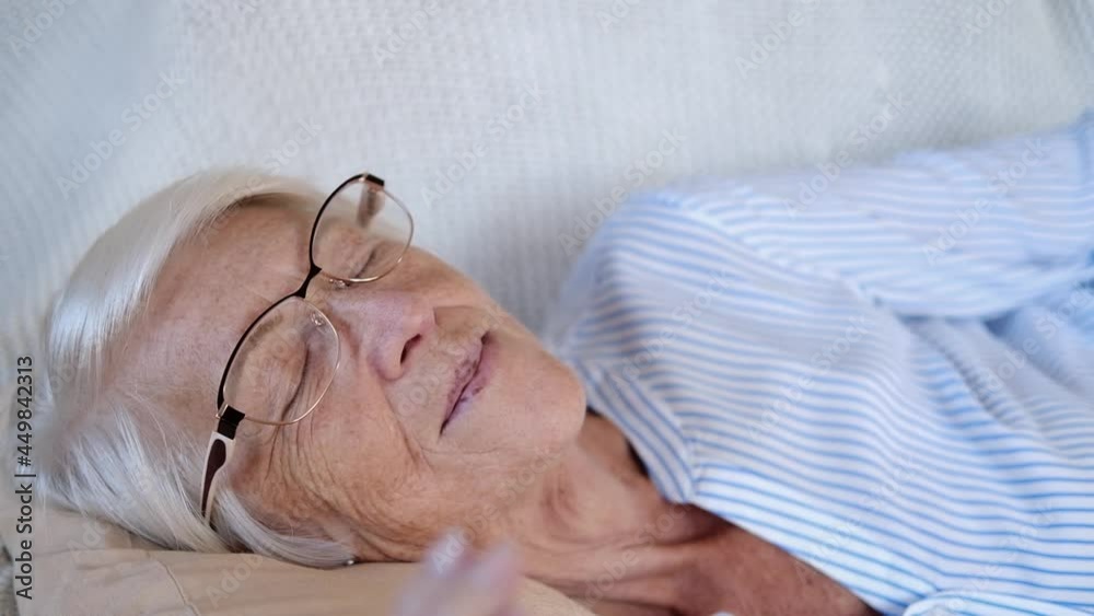 Close up portrait of caucasian happy calm elderly woman sleeping or relax on comfortable sofa at home. taking nap or meditate old lady rest on couch. stress free, peace concept
