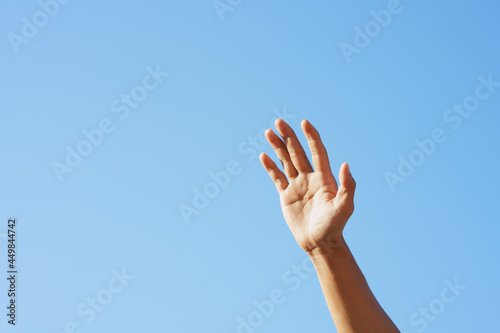 People raising hand, sky background