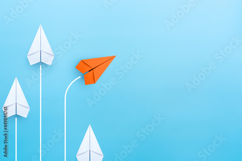 Business concept for new ideas creativity and innovative solution, Group of white paper plane in one direction and one orange paper plane pointing in different way, copy space