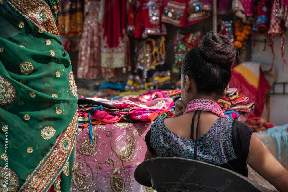 Rear view of a woman selling sari on market