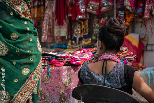 Rear view of a woman selling sari on market © Lord_Ghost
