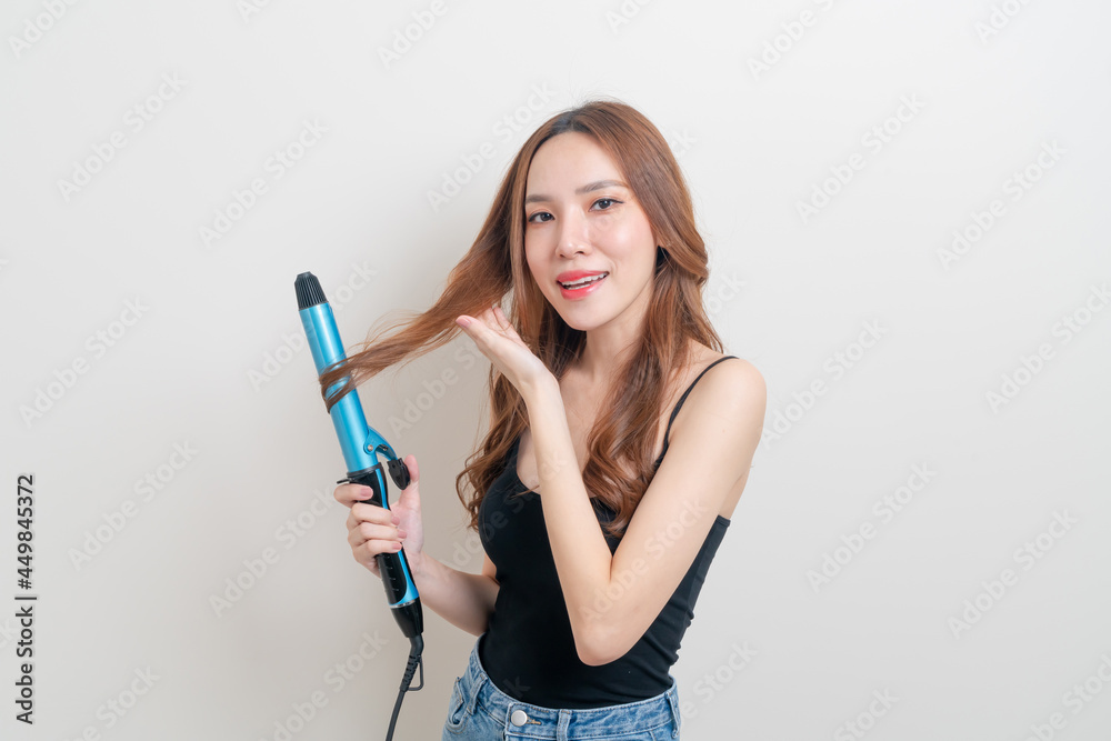 portrait beautiful Asian woman using hair curler or curling iron portrait beautiful Asian woman using hair curler or curling iron
