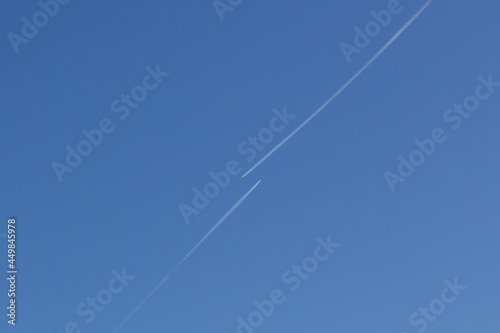 Clear blue sky with condensation trail of plane