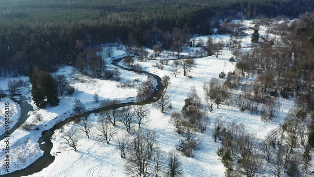 Drone shot flying on forest and river in winter. Frozen trees and river at sunny winter day.
Drone shot flying on forest and river in winter. Frozen trees and river at sunny winter day.