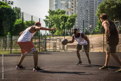 African american man playing basketball near friend on court © LIGHTFIELD STUDIOS