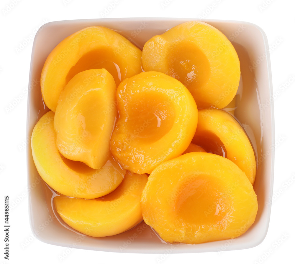 Halves of canned peaches in bowl isolated on white, top view