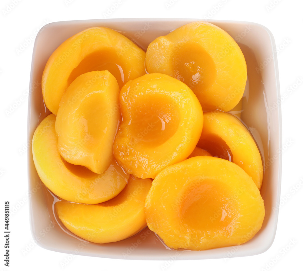 Halves of canned peaches in bowl isolated on white, top view Halves of canned peaches in bowl isolated on white, top view
