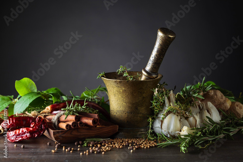 Different herbs and spices on a wooden table .