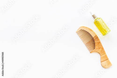 Essential oil for hair care with wooden hair comb