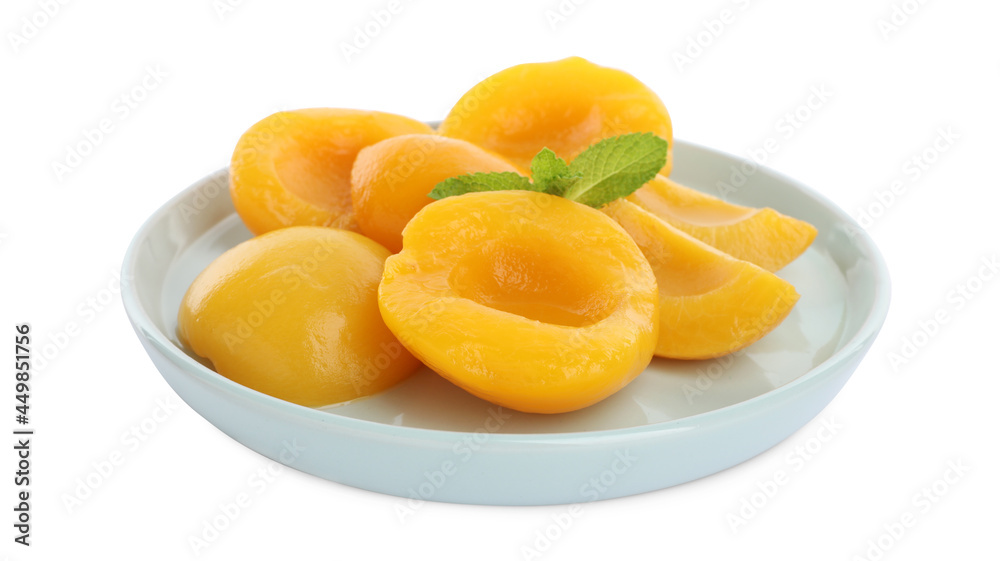 Plate with canned peach halves and mint leaves isolated on white Plate with canned peach halves and mint leaves isolated on white