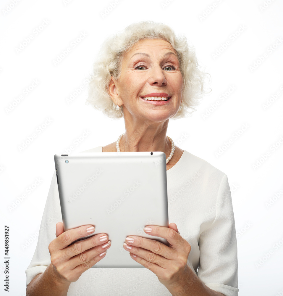 lifestyle, technology and old people concept: Happy mature woman using a tablet lifestyle, technology and old people concept: Happy mature woman using a tablet