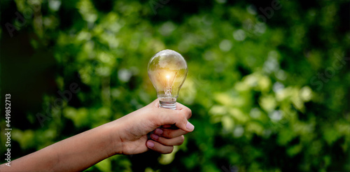 Hand holding light bulb,natural energy and love the world concept. 