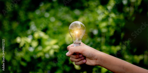 Hand holding light bulb,natural energy and love the world concept. 