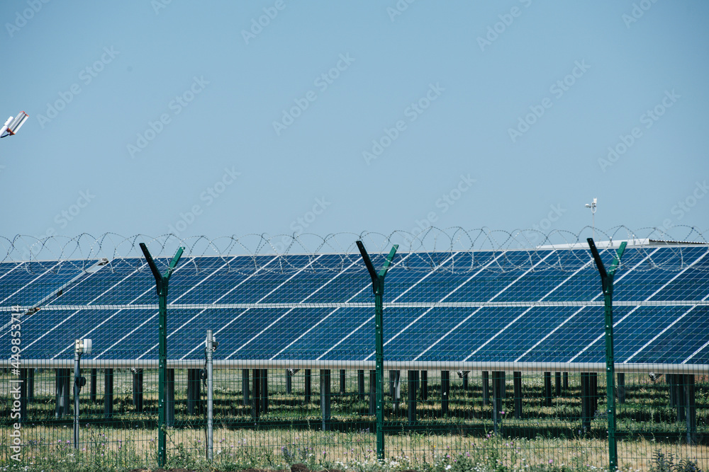 Small solar farm behind a fence. Front view. Small solar farm behind a fence. Front view.