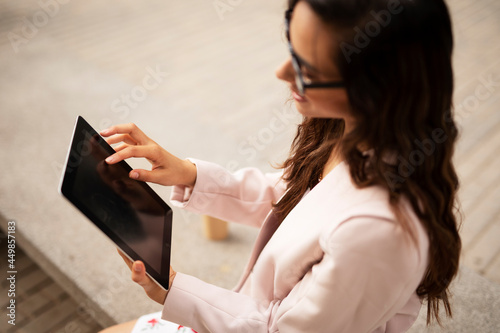 Young businesswoman using tablet outdoors. Beautiful young woman learning online..