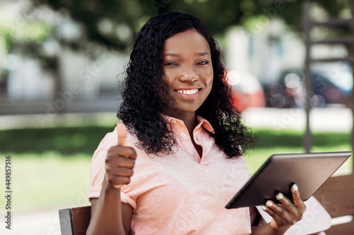 technology, lifestyle and people concept - happy smiling african american woman with tablet pc computer in city showing thumbs up