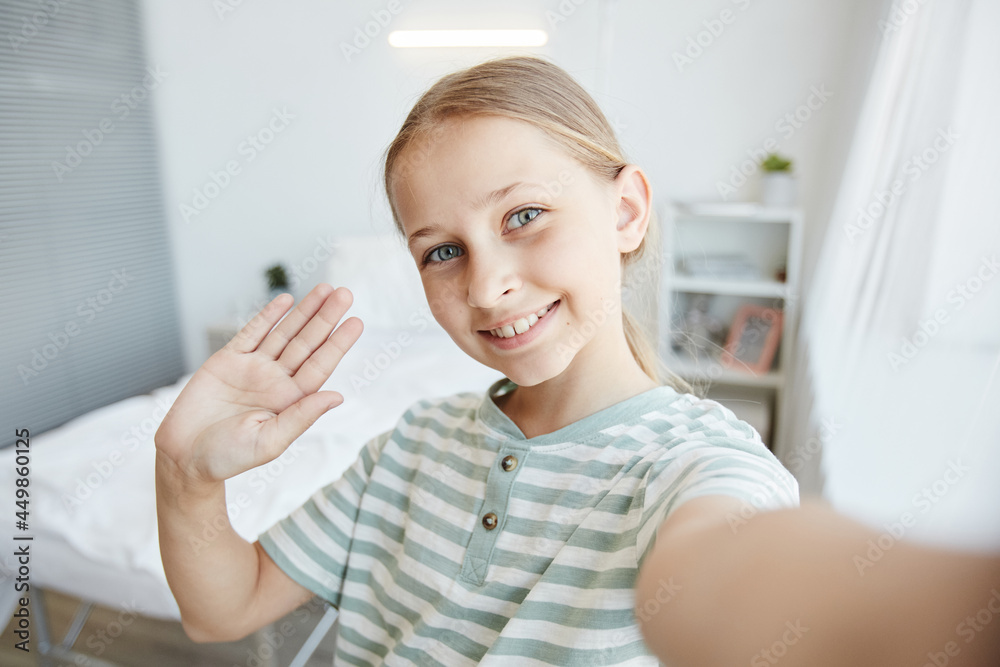 POV shot of smiling girl looking at camera while taking selfie or video chatting in hospital room POV shot of smiling girl looking at camera while taking selfie or video chatting in hospital room