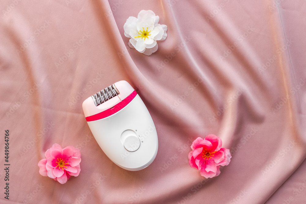 White epilator with flowers - set for hair removal, top view White epilator with flowers - set for hair removal, top view