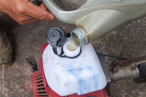 Refueling. Man filling a diesel engine fluid from the tank of fuel and pours it into the engine.