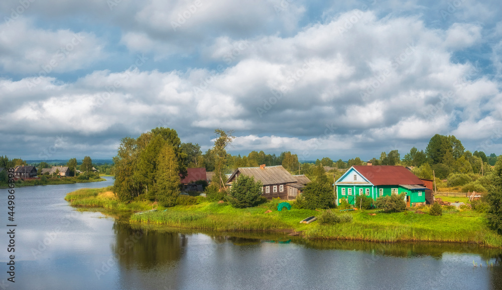 Traditional Russian village in the north of Russia on the river bank in summer