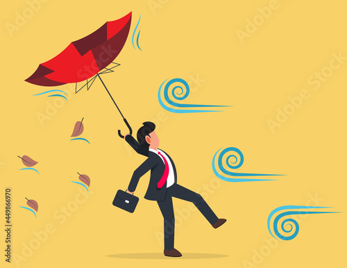 Businessman holding broken umbrella in strong wind storm. Business difficulty or obstacle in economic crisis