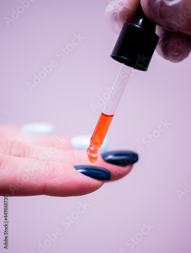 The manicure specialist treats the client's nails with a special moisturizing oil after finishing the procedures