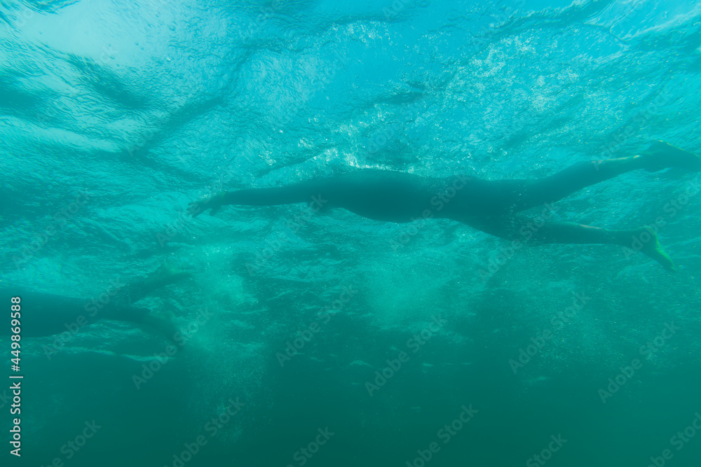 Triathlete swimming in a lake, underwater perspective Triathlete swimming in a lake, underwater perspective