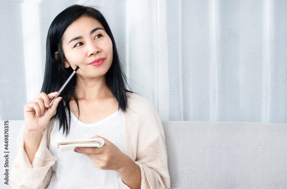 beautiful Asian woman writing, planning to do list on notepad smiling and thinking of goal plan, inspiration beautiful Asian woman writing, planning to do list on notepad smiling and thinking of goal plan, inspiration