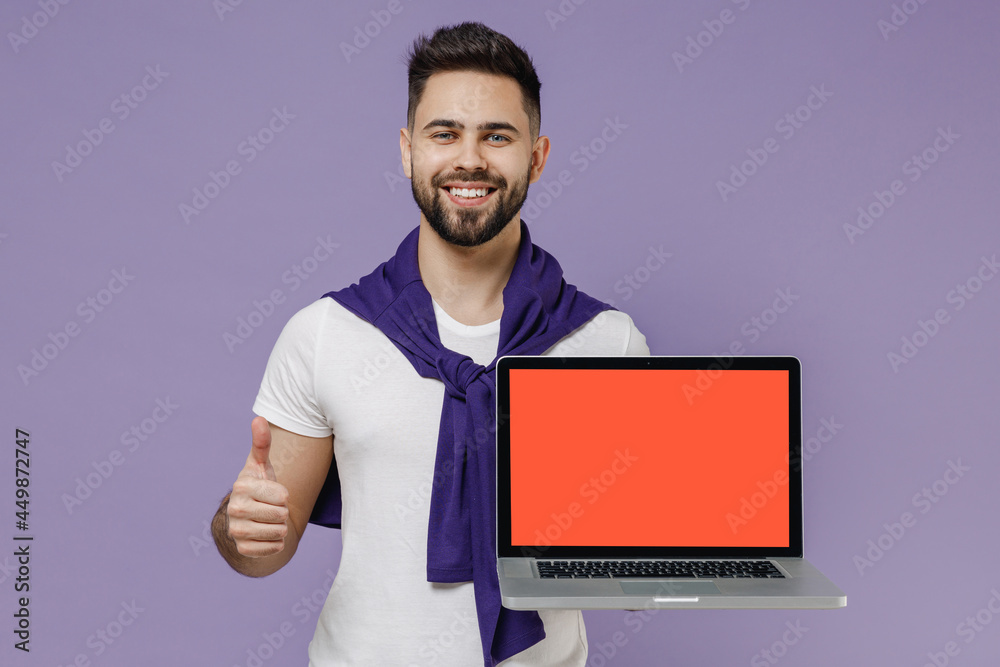 Young brunet man 20s wears white t-shirt purple shirt hold use work on laptop pc computer with blank screen workspace area show thumb up like gesture isolated pastel violet background studio portrait.