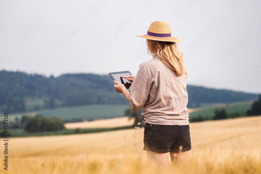 Woman agronomist using digital tablet and modern technology in agricultural field. Female farmer control quality of barley crop before harvesting Woman agronomist using digital tablet and modern technology in agricultural field. Female farmer control quality of barley crop before harvesting