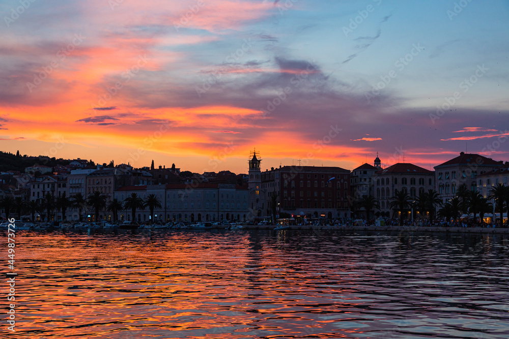 クロアチア　スプリットの旧市街の港沿いの街並みと夕焼けでオレンジ色に染まった空