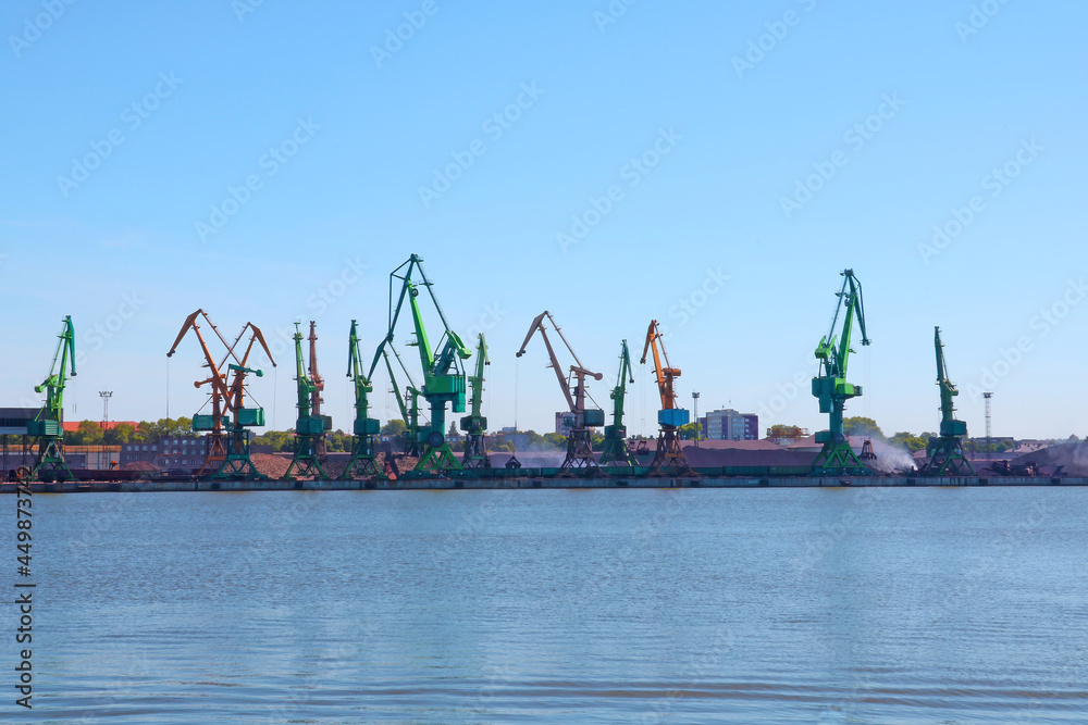 View of industrial cranes in the port at sea.