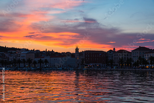 クロアチア スプリットの旧市街の港沿いの街並みと夕焼けでオレンジ色に染まった空