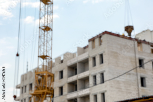 Blurred view of unfinished building and construction crane outdoors