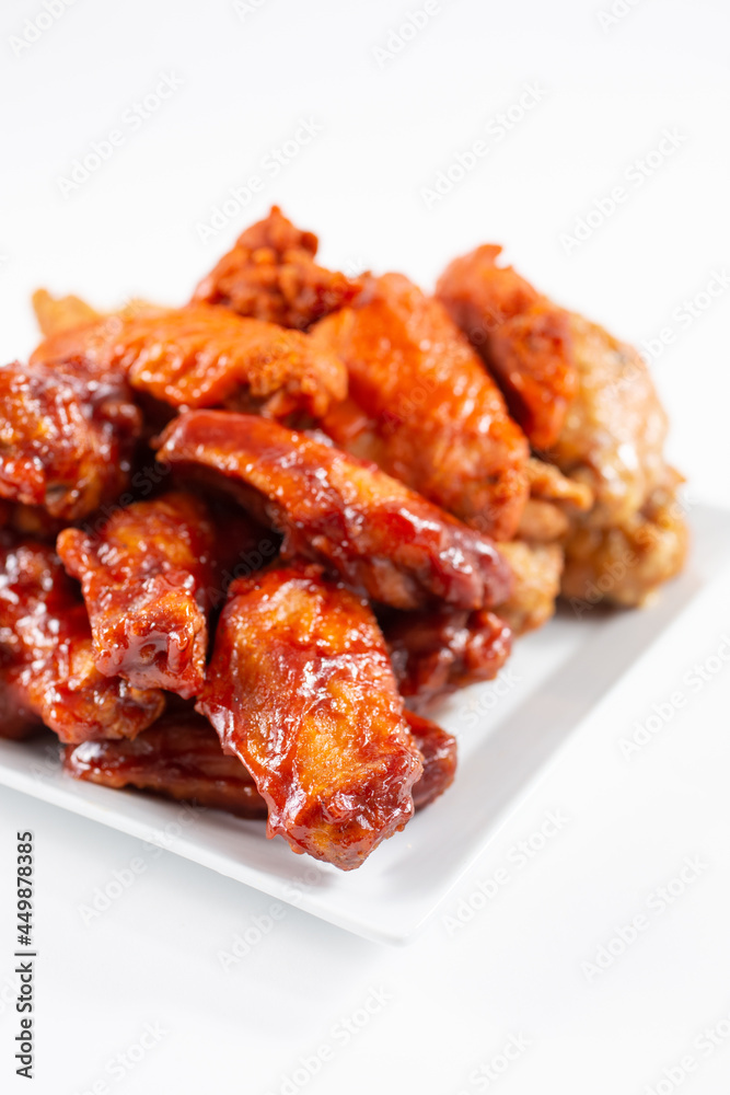 A view of a plate of a chicken wings sampler, featuring flavors as buffalo and BBQ sauce.